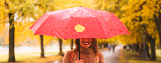 Benefits around the globe image of woman holding pink umbrella