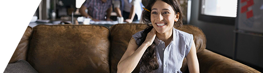 policies and practices hero image of a smiling woman sitting on a couch