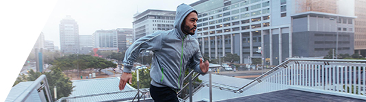 Incentives hero image of a man wearing a hoodie jogging up steps